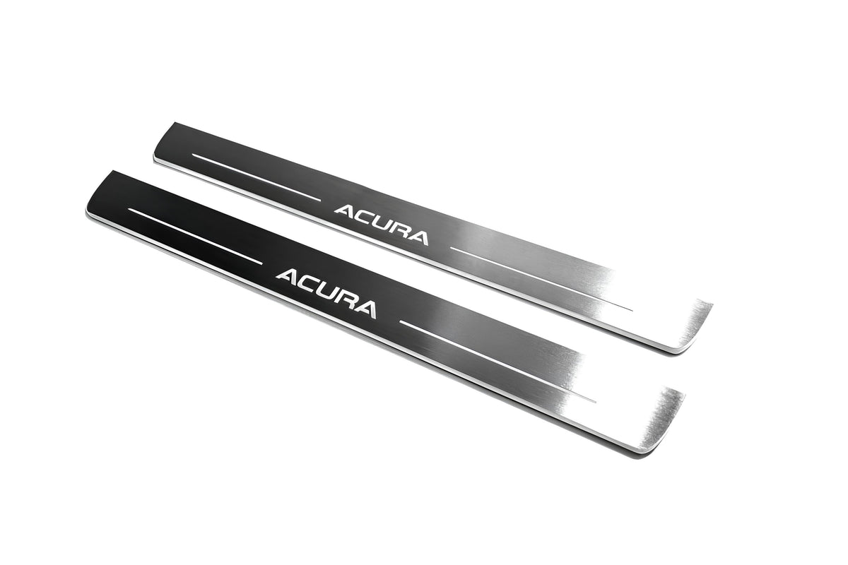 Two long reflective dark door sill plates with white Acura lettering and horizontal lines on a white background, angled view.