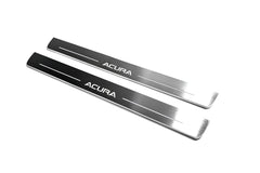 Two long reflective dark door sill plates with white Acura lettering and horizontal lines on a white background, angled view.