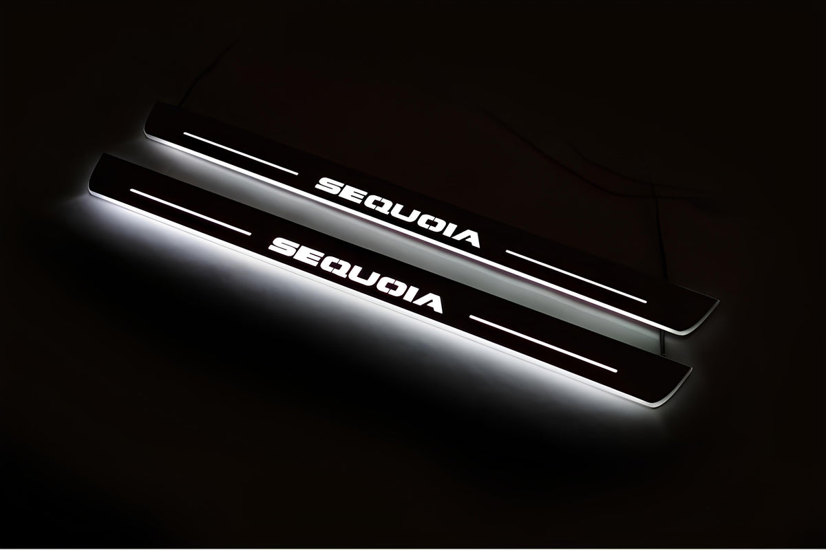 Two long door sill plates with Sequoia lettering and edges illuminated in white, angled view on a dark background.