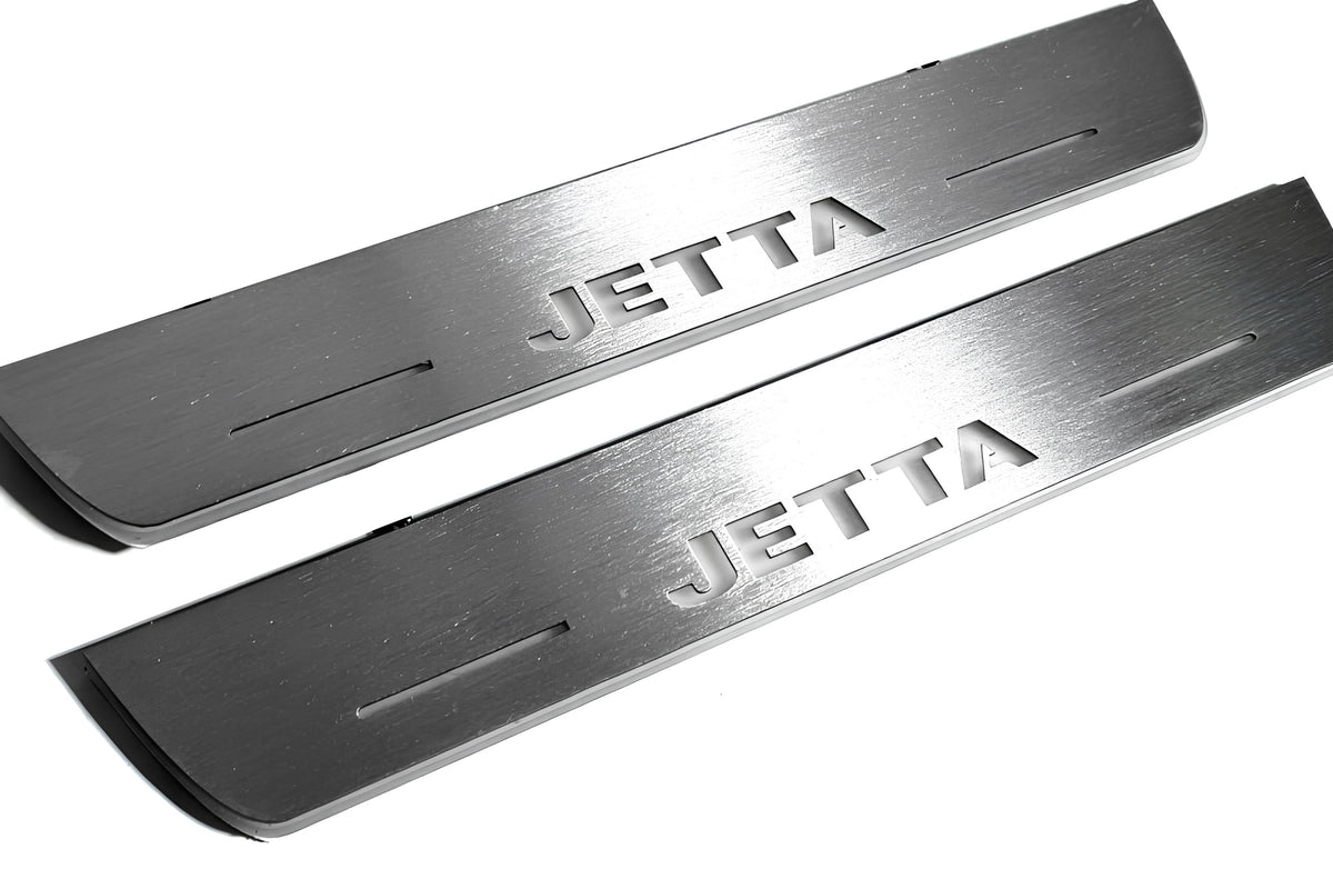 Close-up of Jetta lettering and linear slots in silver-finished door sill plates.