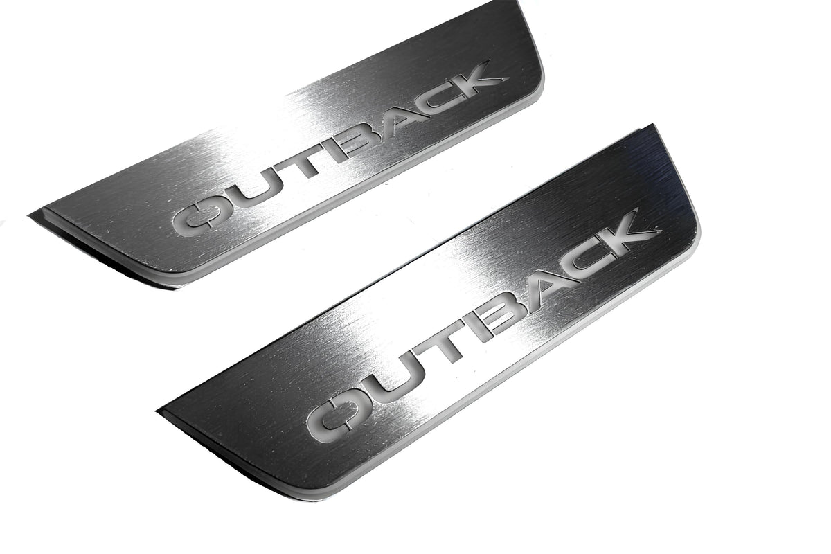 Close-up of Outback lettering and linear slots in silver-finished door sill plates.