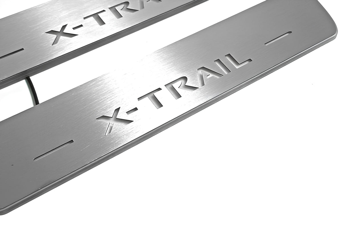 Close-up of X-Trail lettering and linear slots in silver-finished door sill plates.