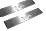 Close-up of H2 lettering and linear slots in silver-finished door sill plates.