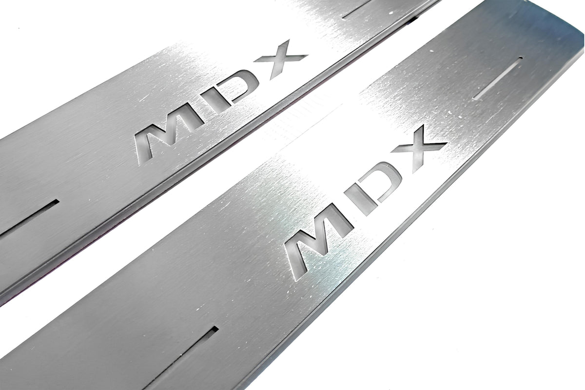 Close-up of MDX lettering and linear slots in silver-finished door sill plates.