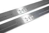 Close-up of H2 lettering and linear slots in silver-finished door sill plates.