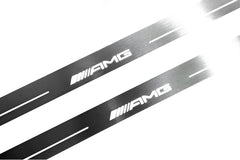 Close-up of AMG lettering and linear slots in silver-finished door sill plates.