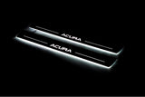 Two long door sill plates with Acura lettering and edges illuminated in white, angled view on a dark background.