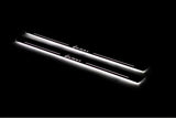 Two long door sill plates with Lanos lettering and edges illuminated in white, angled view on a dark background.