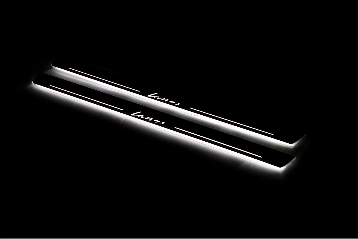 Two long door sill plates with Lanos lettering and edges illuminated in white, angled view on a dark background.