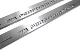 Close-up of M Performance lettering and linear slots in silver-finished door sill plates.