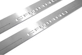Close-up of Camaro lettering and linear slots in silver-finished door sill plates.