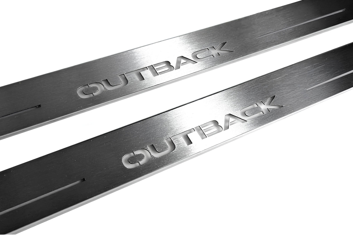 Close-up of Outback lettering and linear slots in silver-finished door sill plates.