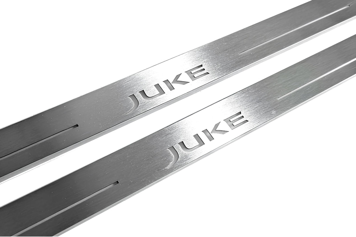 Close-up of Juke lettering and linear slots in silver-finished door sill plates.