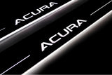 Close-up of Acura lettering and illuminated edges on door sill plates against a dark background.