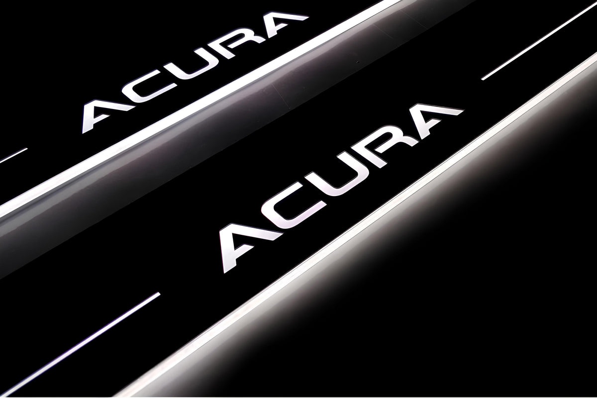 Close-up of Acura lettering and illuminated edges on door sill plates against a dark background.