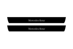 Catalog illustration of two black front door sill plates with Mercedes-Benz lettering.