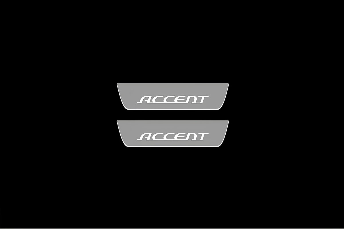 Catalog illustration of two short gray door sill plates with Accent lettering on a black background.