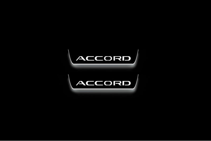 Two short door sill plates with Accord lettering and edges illuminated in white, straight-on view on a dark background.