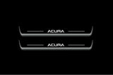 Two long door sill plates with Acura lettering and edges illuminated in white, straight-on view on a dark background.