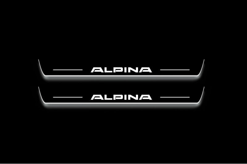 Two long door sill plates with Alpina lettering and edges illuminated in white, straight-on view on a dark background.