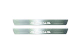 Two long silver-finished door sill plates with Alpina lettering on a light background, straight-on view.
