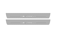 Catalog illustration of two long gray door sill plates with AMG lettering on a white background.