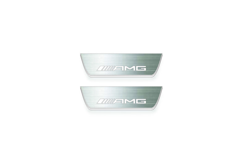 Two short silver-finished door sill plates with AMG lettering on a light background, straight-on view.