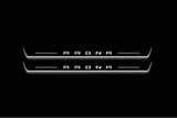 Two long door sill plates with Arona lettering and edges illuminated in white, straight-on view on a dark background.