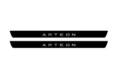 Catalog illustration of two black front door sill plates with Arteon lettering.