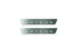 Two short silver-finished door sill plates with Arteon lettering on a light background, straight-on view.