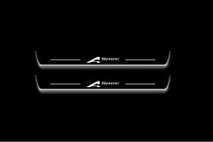 Two long door sill plates with A-Spec lettering and edges illuminated in white, straight-on view on a dark background.