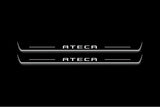 Two long door sill plates with Ateca lettering and edges illuminated in white, straight-on view on a dark background.