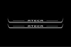 Two long door sill plates with Ateca lettering and edges illuminated in white, straight-on view on a dark background.