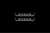 Two short door sill plates with Ateca lettering and edges illuminated in white, straight-on view on a dark background.