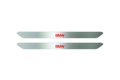 Catalog illustration of two narrow silver door sill inserts with red BMW lettering on a white background.