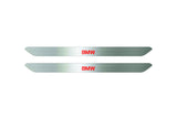 Catalog illustration of two narrow silver door sill inserts with red BMW lettering on a white background.