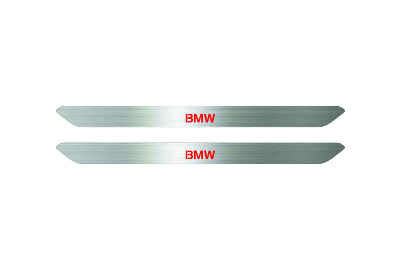 Catalog illustration of two narrow silver door sill inserts with red BMW lettering on a white background.