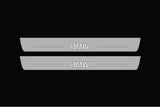 Catalog illustration of two long gray door sill plates with BMW lettering on a black background.