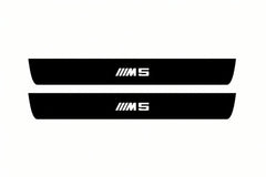 Catalogue illustration of two front black Matte PRO LED door sill plates with illuminated M5 lettering for BMW 5 E61; dimensions are selected during manufacture.