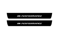 Catalog illustration of two black front door sill plates with ///M Performance lettering.