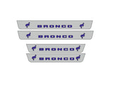 Catalog illustration of four gray door sill plates with blue Bronco lettering and bucking horse emblems.