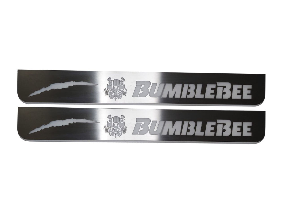 Two silver-finished door sill plates with Bumblebee lettering, character emblems and one claw mark.