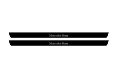 Catalog illustration of two black front door sill plates with Mercedes-Benz lettering.