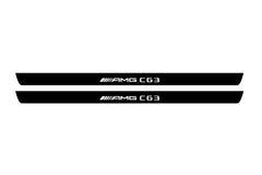 Catalog illustration of two black front door sill plates with AMG С63 lettering.