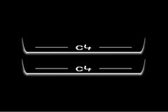 Two long door sill plates with C4 lettering and edges illuminated in white, straight-on view on a dark background.