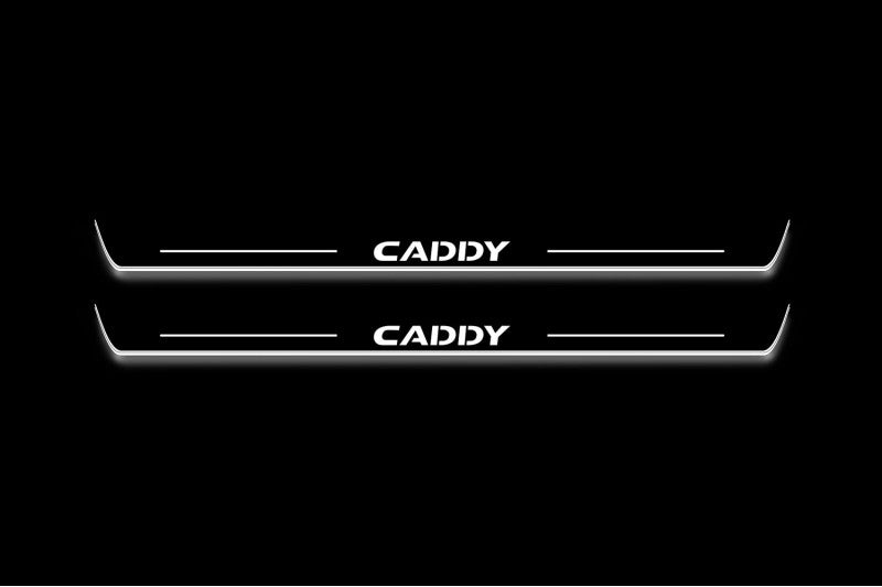 Two long door sill plates with Caddy lettering and edges illuminated in white, straight-on view on a dark background.
