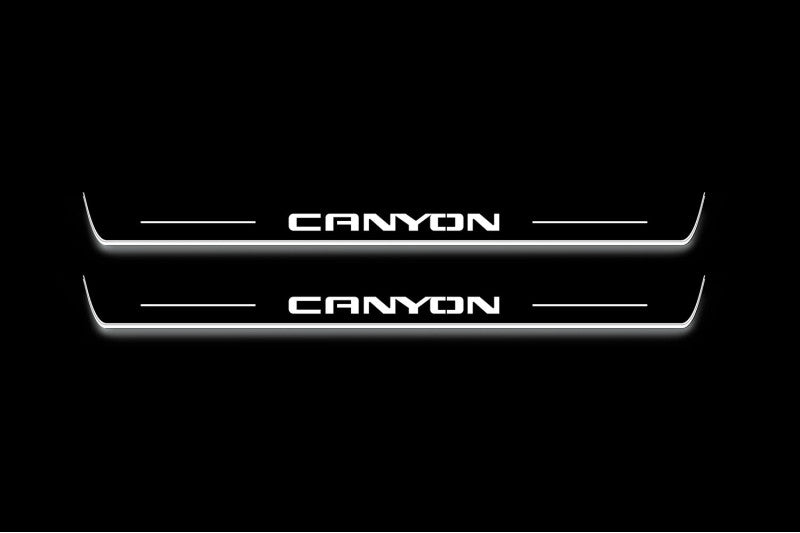 Two long door sill plates with Canyon lettering and edges illuminated in white, straight-on view on a dark background.