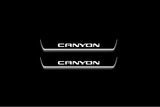 Two short door sill plates with Canyon lettering and edges illuminated in white, straight-on view on a dark background.