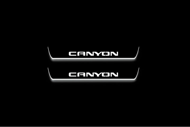 Two short door sill plates with Canyon lettering and edges illuminated in white, straight-on view on a dark background.