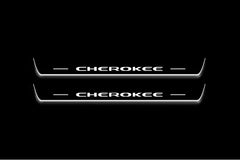 Two long door sill plates with Cherokee lettering and edges illuminated in white, straight-on view on a dark background.